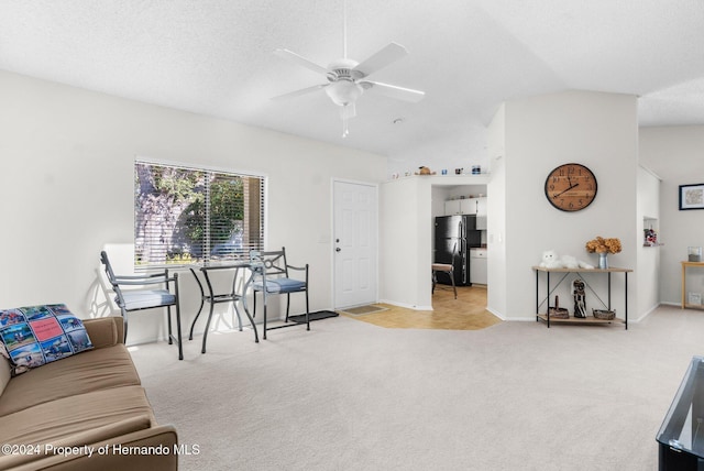 living room featuring a textured ceiling, light colored carpet, vaulted ceiling, and ceiling fan