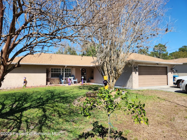 ranch-style home featuring an attached garage, driveway, a front yard, and brick siding