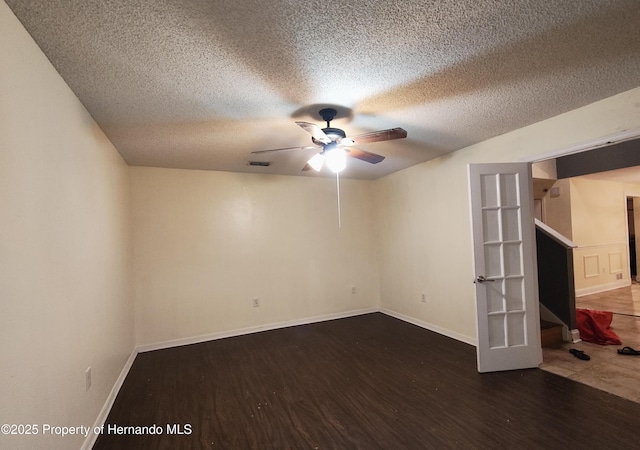 spare room featuring ceiling fan, french doors, dark hardwood / wood-style flooring, and a textured ceiling