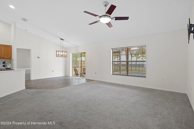 unfurnished living room with ceiling fan with notable chandelier, carpet floors, and lofted ceiling