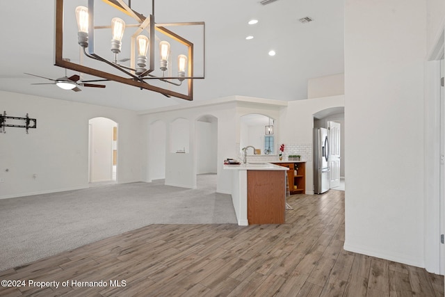 interior space with ceiling fan with notable chandelier, light hardwood / wood-style floors, and sink