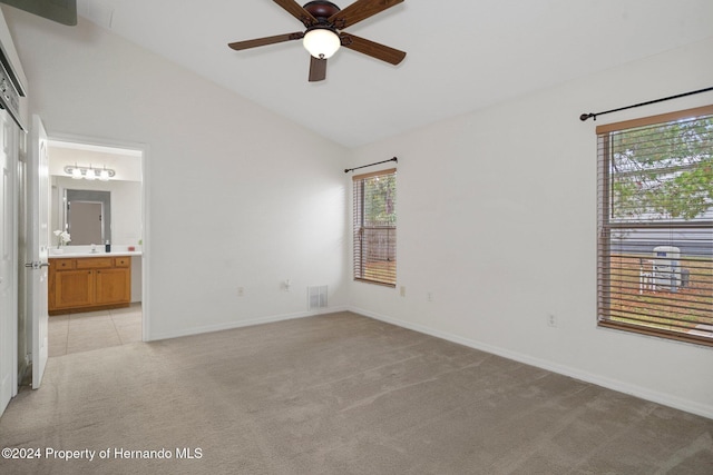 carpeted empty room featuring ceiling fan and vaulted ceiling