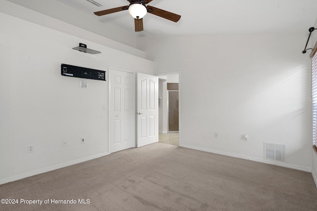 interior space featuring ceiling fan, light carpet, and high vaulted ceiling