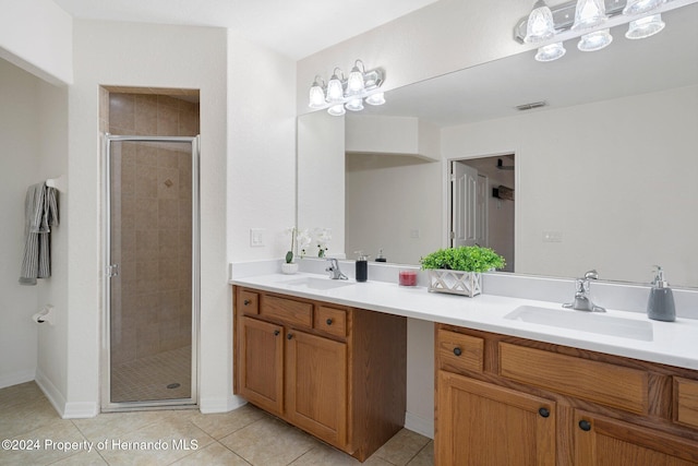 bathroom with tile patterned flooring, vanity, and an enclosed shower