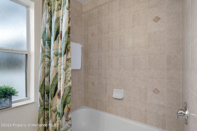 bathroom featuring plenty of natural light and shower / tub combo