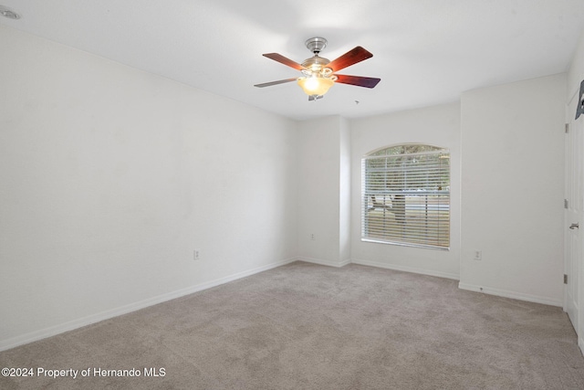 carpeted spare room with ceiling fan