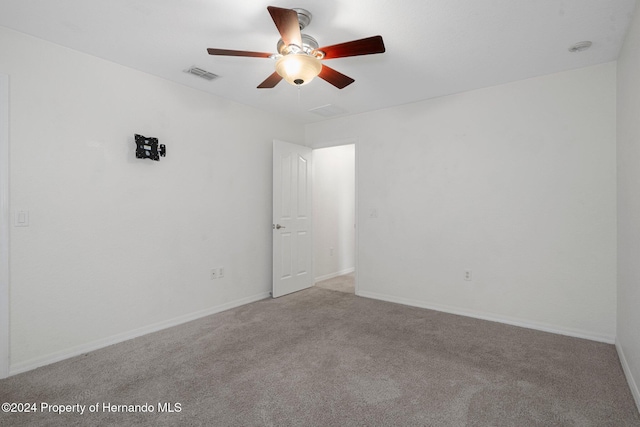 carpeted spare room with ceiling fan