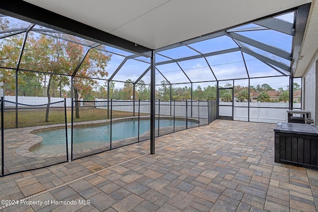 view of swimming pool with glass enclosure and a patio