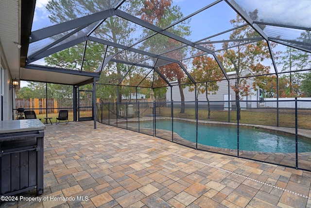 view of swimming pool with a patio and glass enclosure