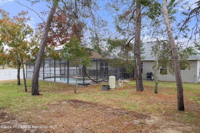 view of yard with a lanai and a fenced in pool