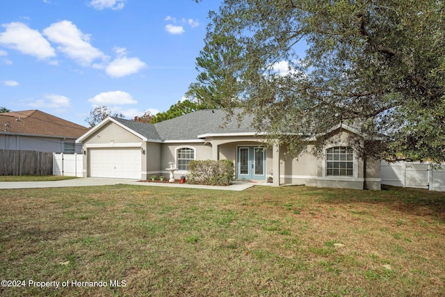 ranch-style home featuring french doors, a garage, and a front lawn