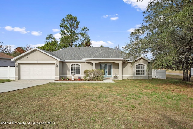 ranch-style home with a front yard, a garage, and french doors