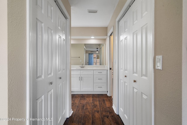 corridor featuring dark wood-type flooring and sink