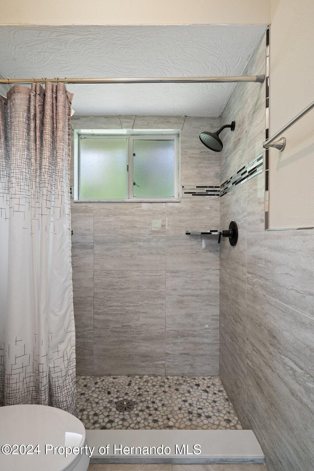 bathroom with a shower with curtain and toilet