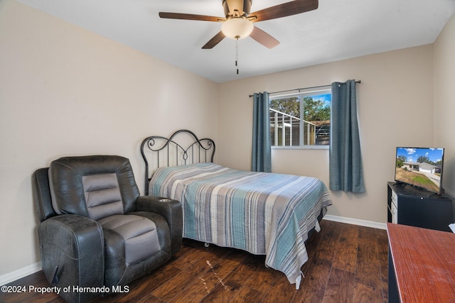 bedroom with dark hardwood / wood-style flooring and ceiling fan