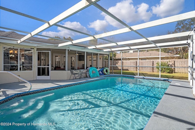 view of swimming pool with glass enclosure and a patio area