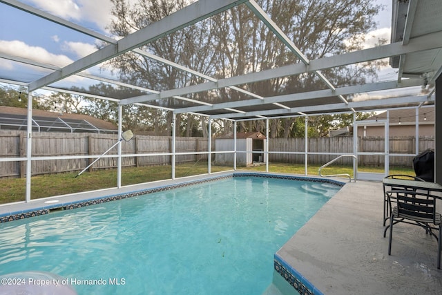 view of swimming pool featuring glass enclosure and a patio