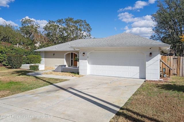 single story home featuring a front lawn and a garage