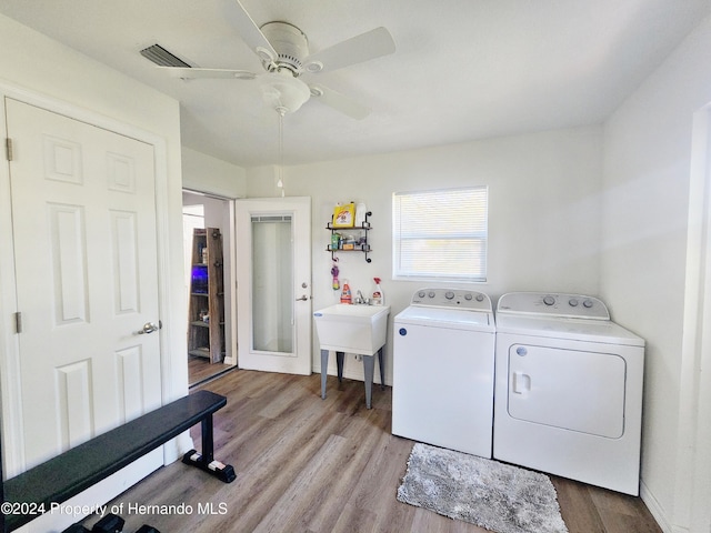 laundry area featuring washing machine and dryer, light hardwood / wood-style flooring, ceiling fan, and sink