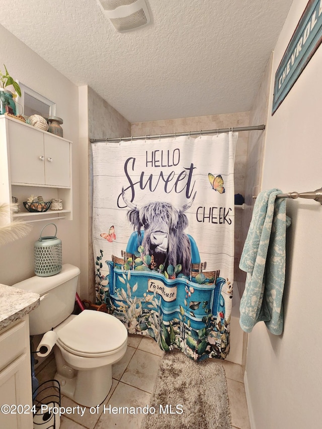 bathroom with tile patterned floors, vanity, a textured ceiling, and toilet