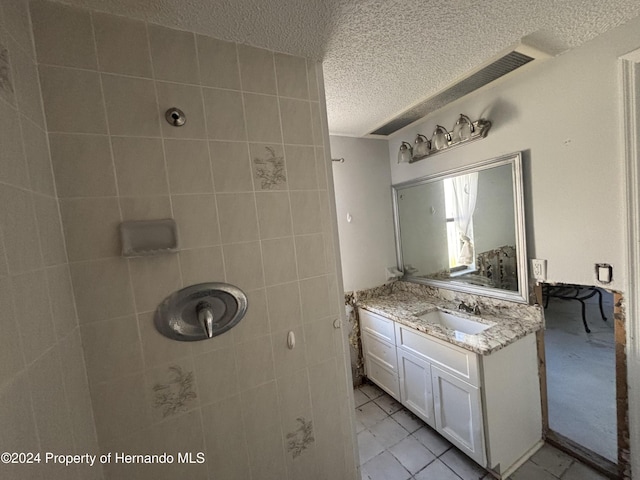 bathroom featuring vanity, a textured ceiling, and tile patterned flooring