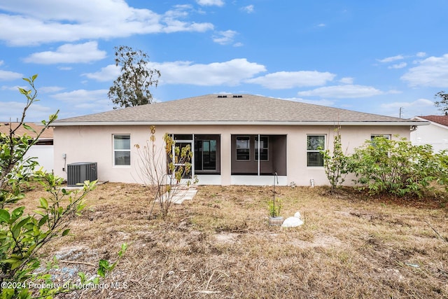 back of property with a sunroom and central AC