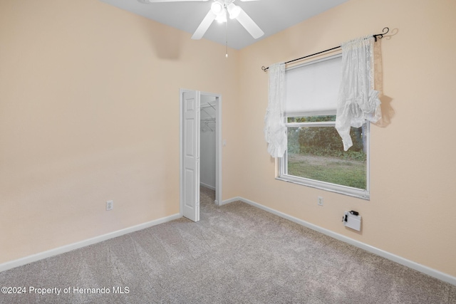 carpeted spare room featuring ceiling fan