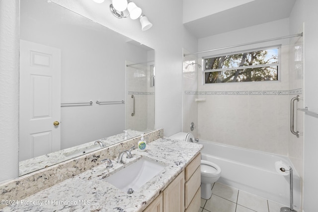 full bathroom featuring tile patterned floors, tiled shower / bath, vanity, and toilet