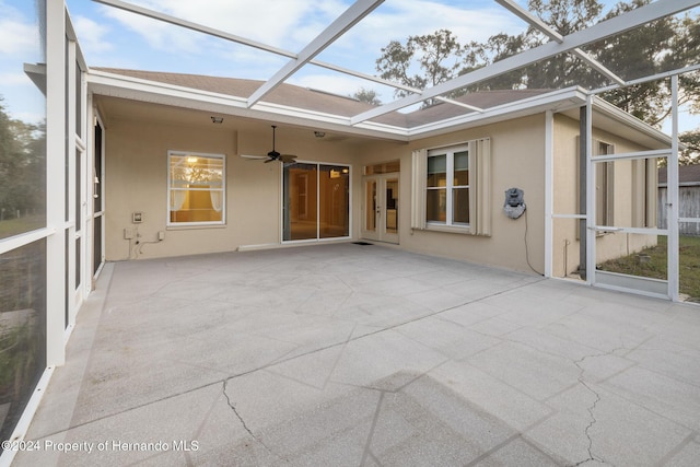 unfurnished sunroom featuring ceiling fan and a healthy amount of sunlight