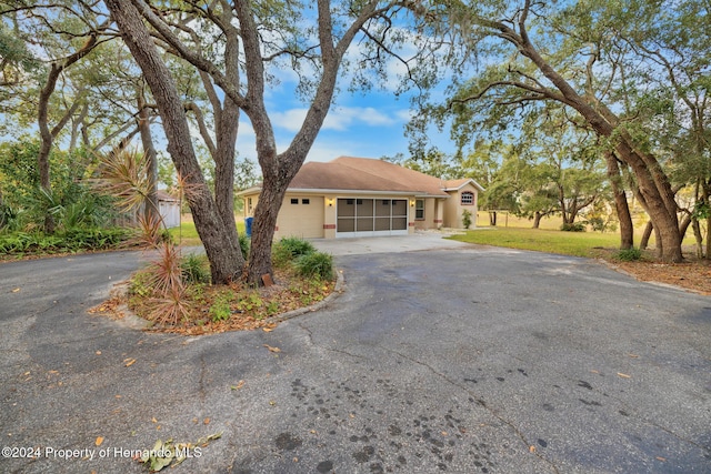 ranch-style house featuring a garage and a front lawn