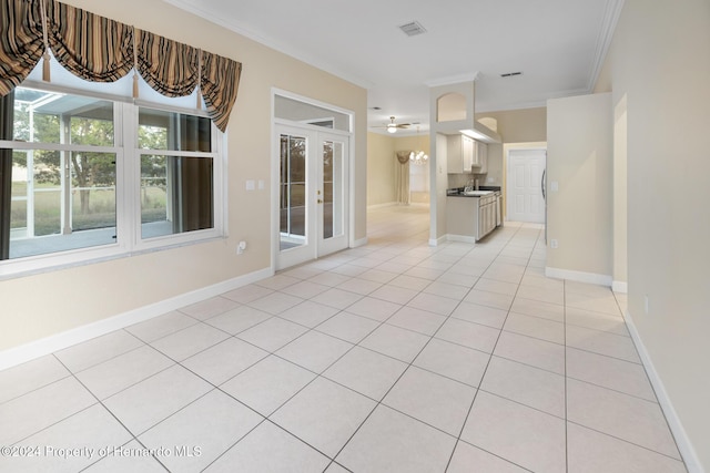 unfurnished living room with ceiling fan, crown molding, and light tile patterned flooring