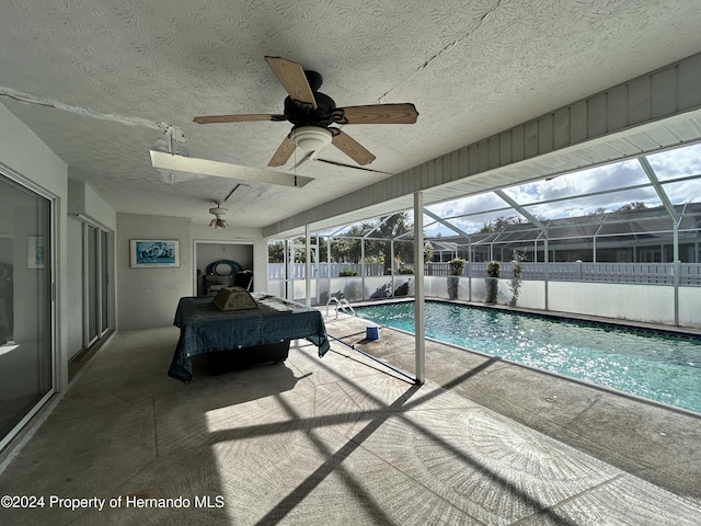 view of swimming pool featuring a lanai and a patio