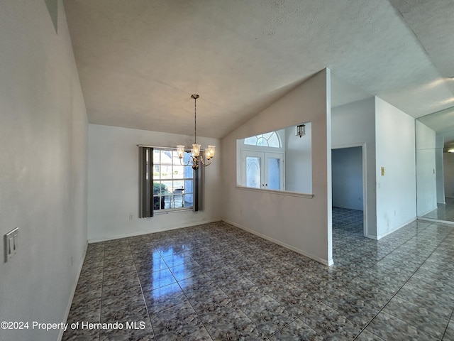 unfurnished dining area featuring a textured ceiling, a chandelier, and lofted ceiling