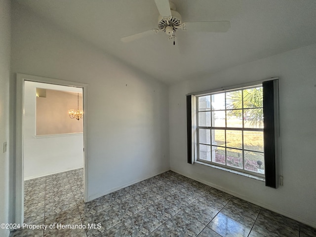 unfurnished room with ceiling fan with notable chandelier and vaulted ceiling