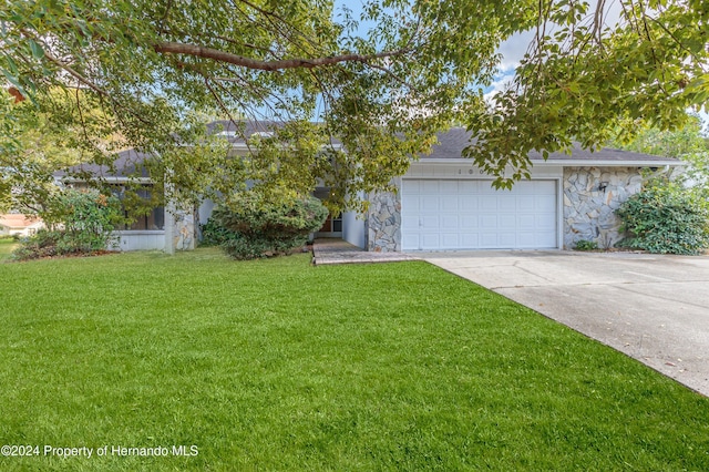 view of front of property featuring a garage and a front lawn