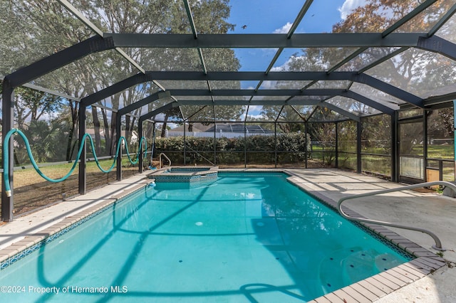 view of swimming pool featuring a lanai, a patio area, and an in ground hot tub