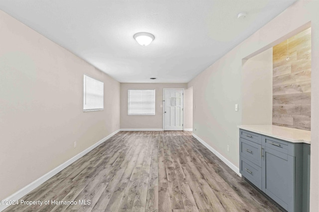 unfurnished living room featuring light hardwood / wood-style floors and wooden walls