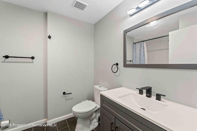 bathroom with walk in shower, tile patterned flooring, vanity, and toilet