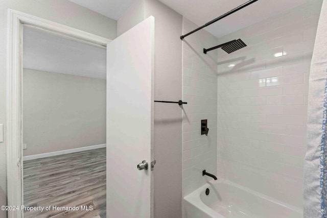 bathroom featuring wood-type flooring and tiled shower / bath