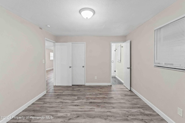 unfurnished bedroom featuring a textured ceiling and light hardwood / wood-style flooring