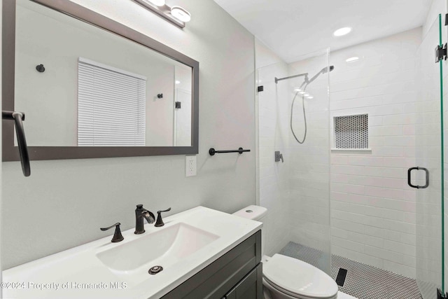 bathroom featuring toilet, an enclosed shower, and vanity