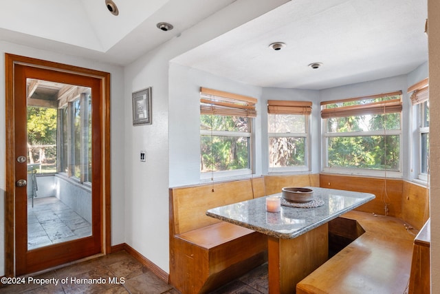 dining room with breakfast area, vaulted ceiling, and a wealth of natural light