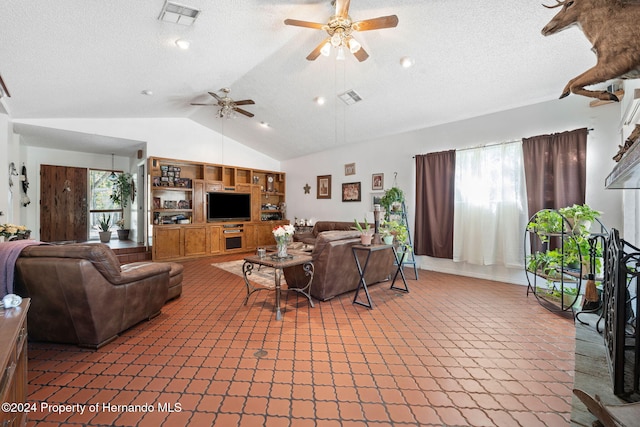 living room with a textured ceiling, ceiling fan, and lofted ceiling