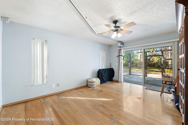 interior space featuring ceiling fan, a textured ceiling, and light wood-type flooring