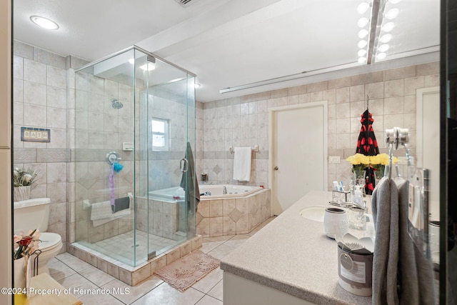 full bathroom with vanity, tile patterned floors, tile walls, and independent shower and bath