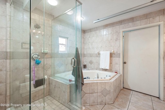 bathroom with tile patterned flooring, shower with separate bathtub, and tile walls