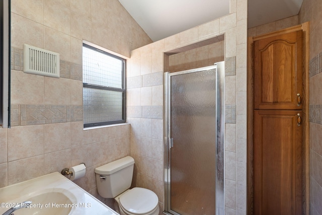 bathroom with an enclosed shower, toilet, tile walls, and sink