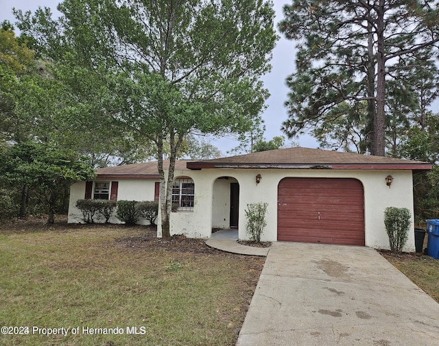 single story home featuring a garage and a front lawn