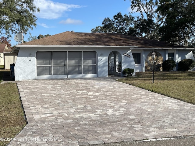 single story home featuring a garage and a front lawn