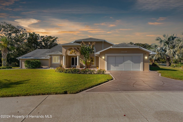 view of front of property featuring a lawn and a garage